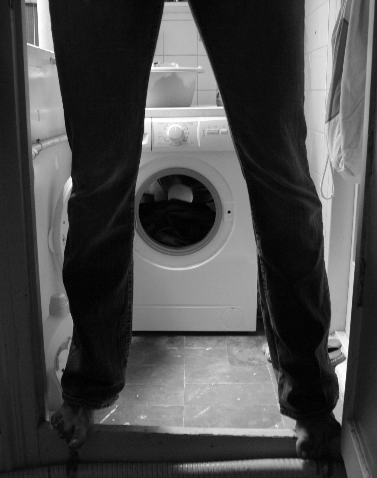 Photo description: a washing machine in the background; two legs in the foreground