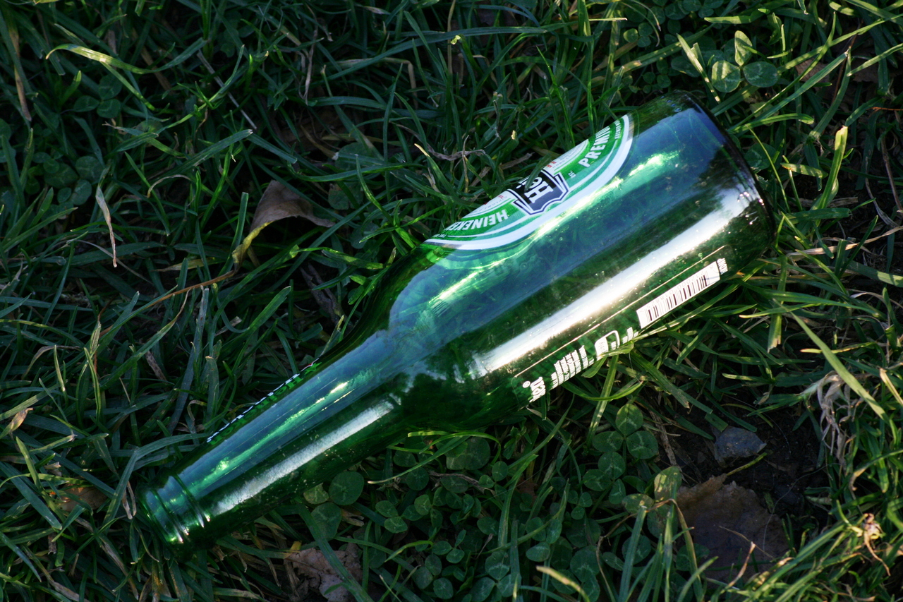 Photo description: Botella verde sobre césped.