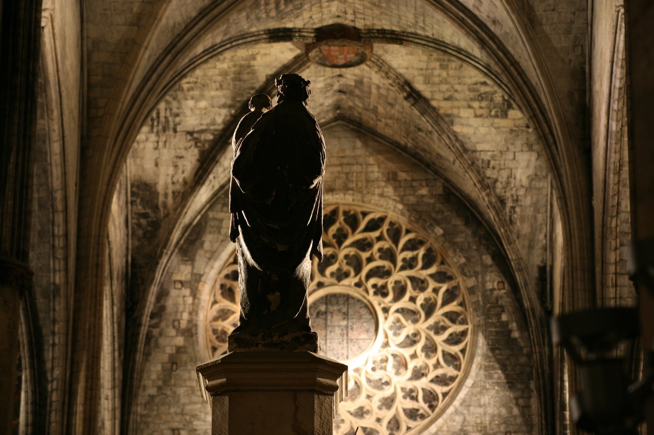 Photo description: Virgen con el Niño, de espaldas. La Catedral de Santa María del mMar, al fondo, por dentro.